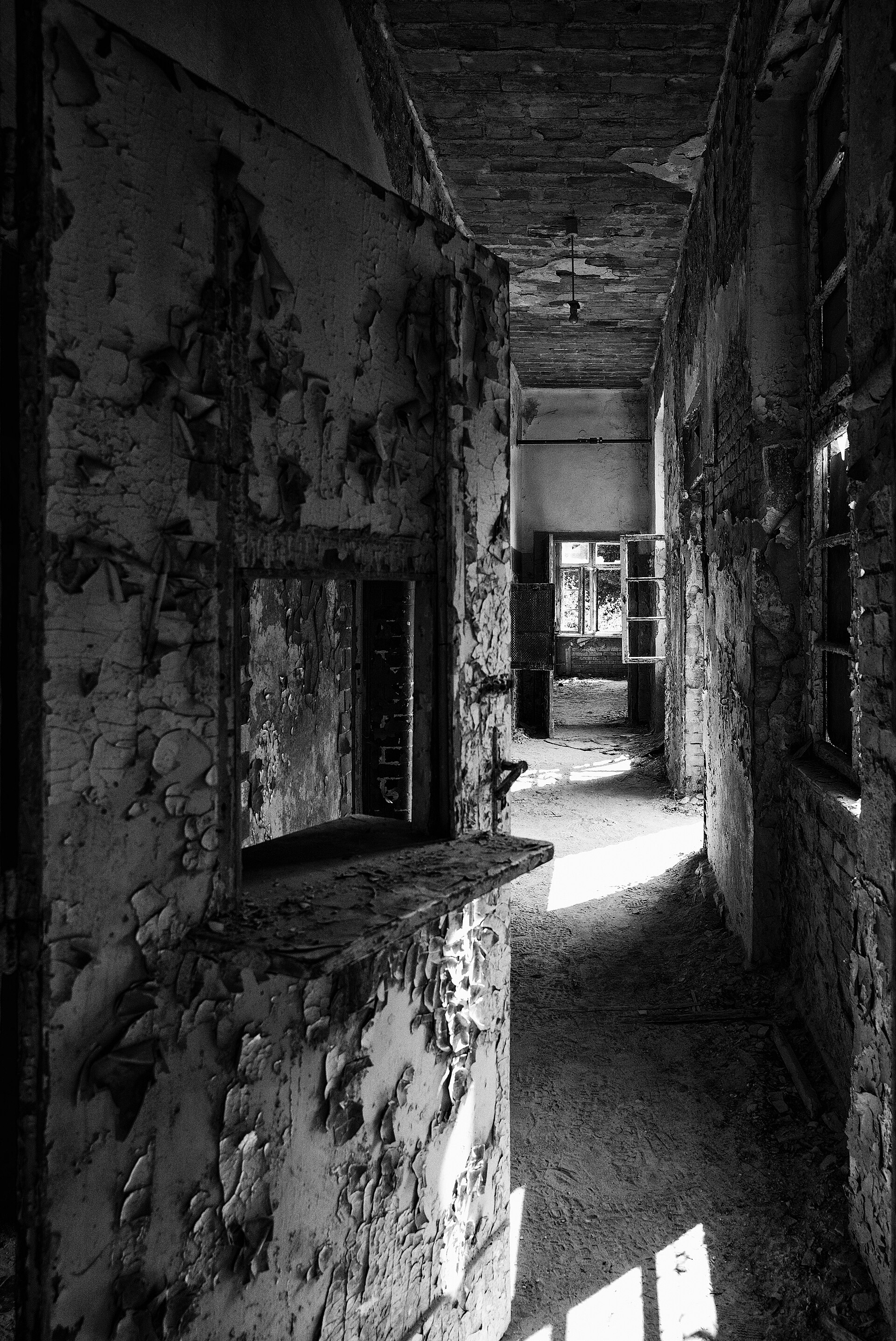 Long corridor inside Heilst&auml;tte Grabowsee with weathered walls and tall windows.
